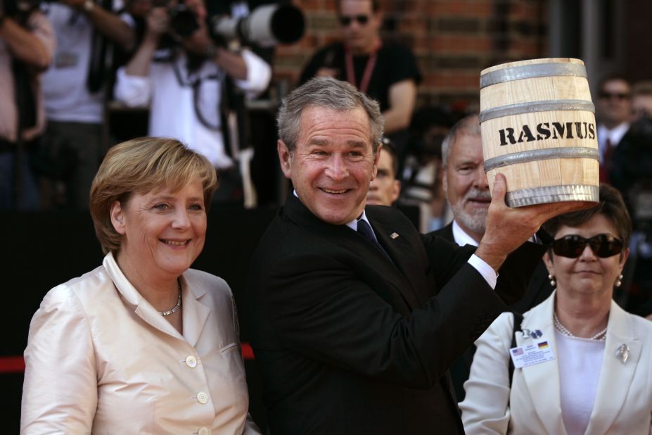 US President George W. Bush shows off a barrel of pickled herrings he was presented after arriving in Stralsund, Germany, in July 2006.