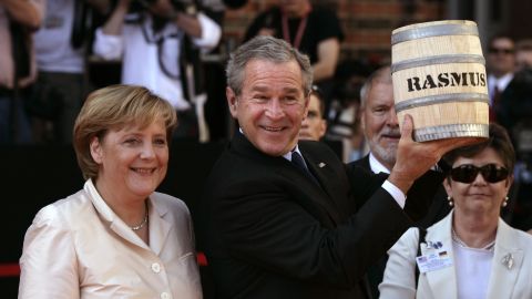 US President George W. Bush shows off a barrel of pickled herrings he was presented after arriving in Stralsund, Germany, in July 2006.