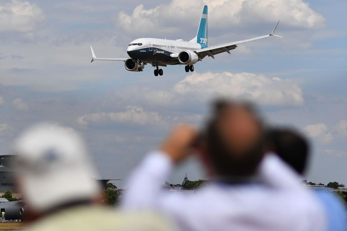 Visitors watch as a Boeing 737 Max lands after an air display during the Farnborough Airshow, south west of London, on July 16, 2018.