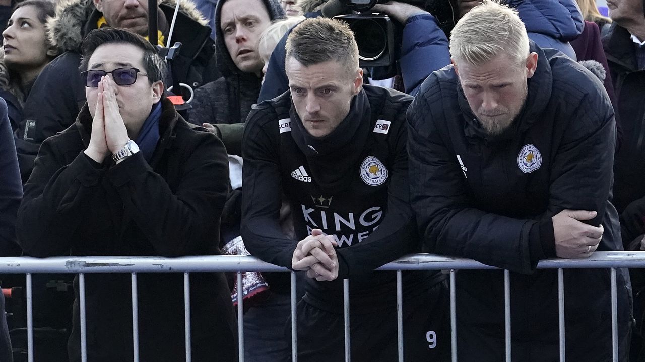 Aiyawatt Srivaddhanaprabha (left), son of the late Leicester City owner, stands with striker Jamie Vardy (center) and goalkeeper Kasper Schmeichel.
