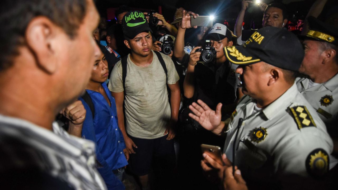 Honduran migrants taking part in a new caravan heading to the US, talk with Guatemalan police officers on their arrival to Chiquimula, Guatemala, on October 22, 2018. - US President Donald Trump on Monday called the migrant caravan heading toward the US-Mexico border a national emergency, saying he has alerted the US border patrol and military.