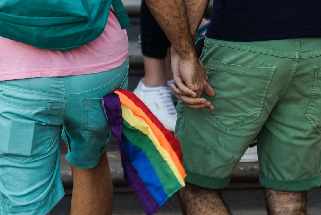 A couple of activists hold hands during the 15th LGBTI March with the slogan "Memory, Pride and Resistance for LGBTI persons rights" in Asuncion, Paraguay on September 29, 2018.