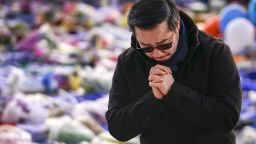 LEICESTER, ENGLAND - OCTOBER 29: Aiyawatt Srivaddhanaprabha the son of Leicester City's Thai chairman Vichai Srivaddhanaprabha who died in a helicopter crash at the club's stadium, pays his respects among the sea of tributes to the victims of the crash at Leicester City Football Club's King Power Stadium on October 28, 2018 in Leicester, England. The owner of Leicester City Football Club, Vichai Srivaddhanaprabha, was among the five people who died in the helicopter crash on Saturday evening after the club's game against  West Ham. (Photo by Christopher Furlong/Getty Images)