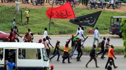 Members of Islamic Movement of Nigeria (IMN) wave flags and chant slogans as they take part in a demonstration to protest against the imprisonnement of a Shiite, in Abuja, on October 29, 2018. - The army and police confronted members of the Islamic Movement of Nigeria (IMN), the group's spokesman Ibrahim Musa told AFP, amid reports of casualties. Rights groups have accused Nigeria's military of killing more than 300 IMN supporters and burying them in mass graves during the 2015 confrontation, a charge the military strongly denies. (Photo by Sodiq ADELAKUN / AFP)        (Photo credit should read SODIQ ADELAKUN/AFP/Getty Images)