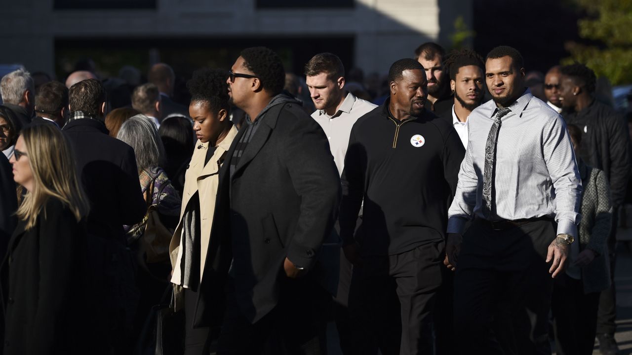 Members of the Pittsburgh Steelers stand with others Tuesday morning outside the Rodef Shalom Temple, where the services for the Rosenthal brothers were to be held. 