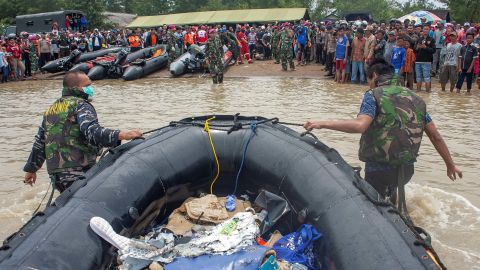 Soldiers push an inflatable raft as they carry debris from the Lion Air flight JT610 airplane that crashed into the sea.