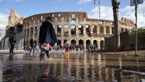Children play Tuesday in a puddle by the ancient Colosseum in Rome, a day after strong winds and rain hit the city.