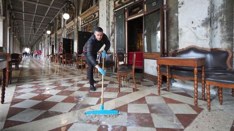 A man brushes away floodwater outside the historic Caffe Florian in St. Mark's Square on Tuesday.