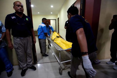 Officials transport a body bag in Jakarta.