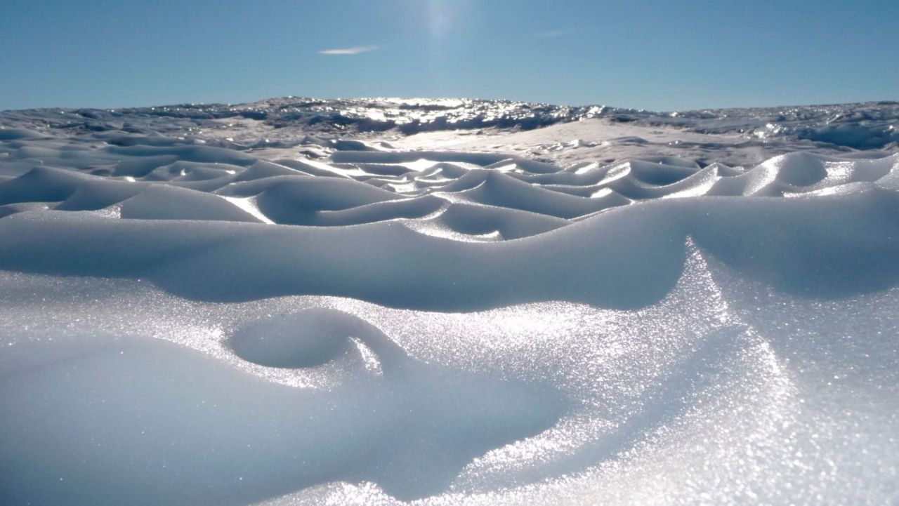 Sastrugi is the term for these hard ridges on the snow and ice, sculpted by strong winds. 