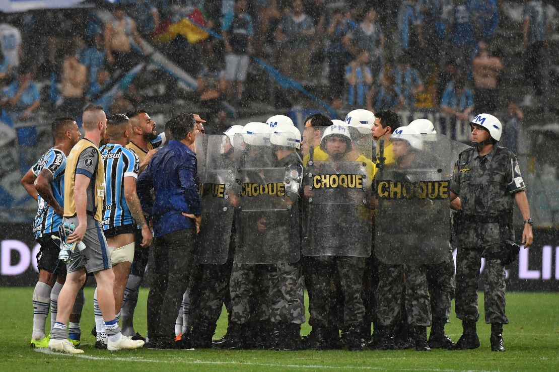 Riot police protect Uruguayan referee Andres Cunha from Gremio' footballers.