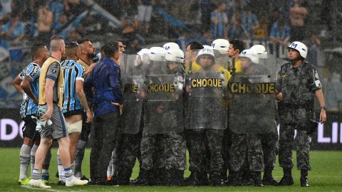 Riot police protect Uruguayan referee Andres Cunha from Gremio' footballers.