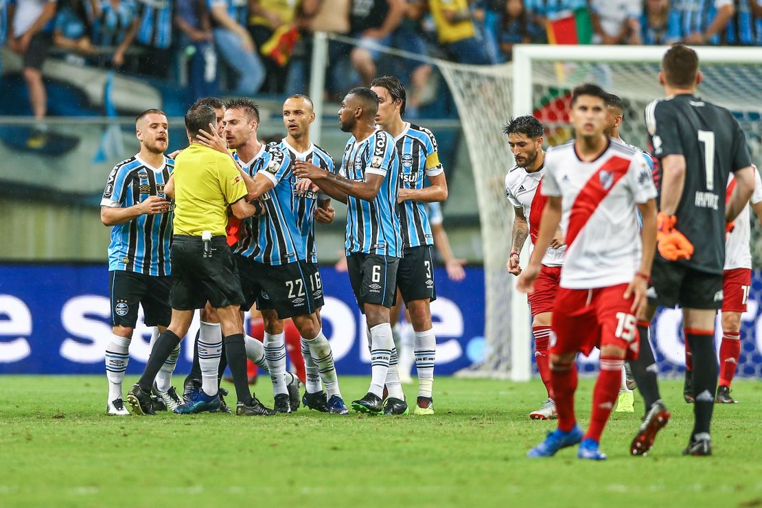 Matheus Bressan confronts referee Andres Cunha after receiving a red card.