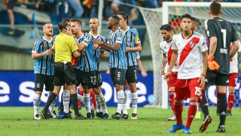 Matheus Bressan confronts referee Andres Cunha after receiving a red card.
