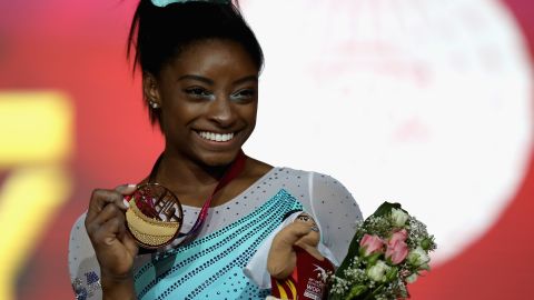 Simone Biles shows off one of her four gold medals from the world championships. 