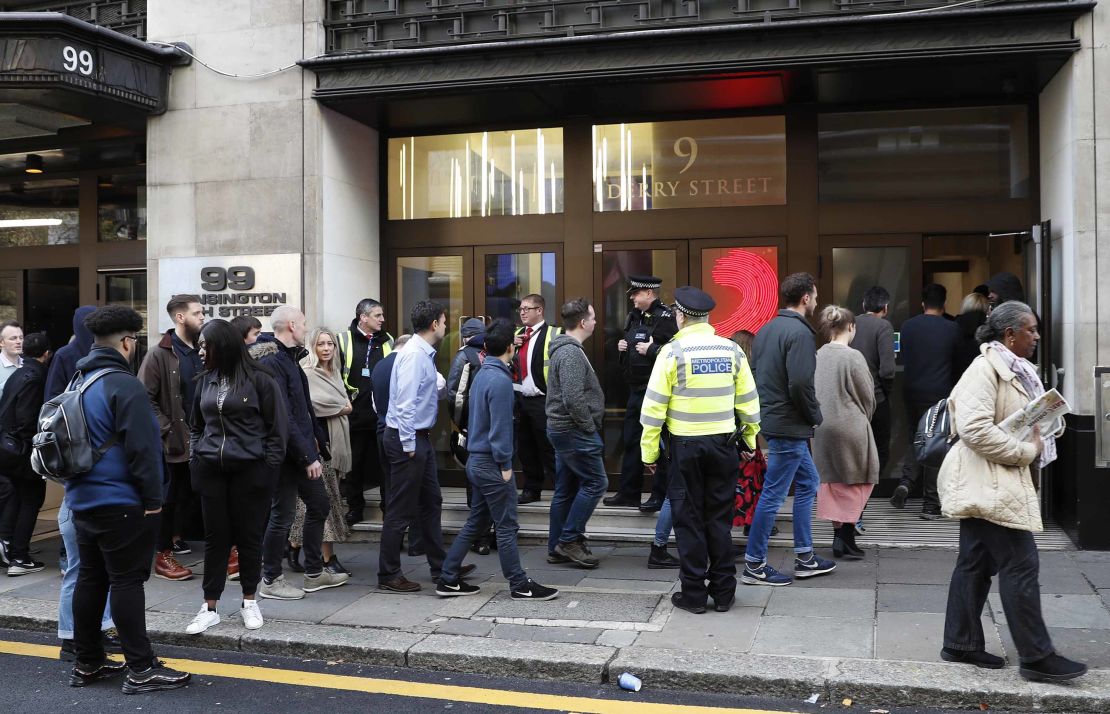 Police officers and security watch as people re-enter a building after a stabbing incident in Derry Street on Friday.
