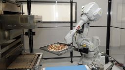 A robot places a pizza into an oven at Zume Pizza.