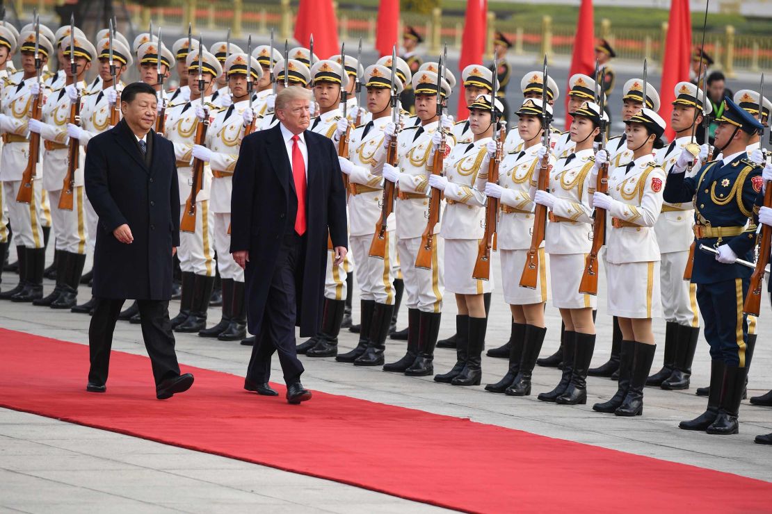 China's President Xi Jinping (L) and US President Donald Trump review Chinese honour guards in Beijing on November 9, 2017.