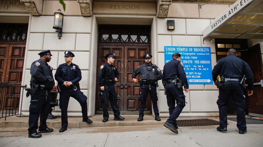 NYPD officers stand guard at the door of the Union Temple of Brooklyn on November 2, 2018 in New York City. - New York police were investigating anti-Semitic graffiti found inside a Brooklyn synagogue that forced the cancellation of a political event less than a week after the worst anti-Semitic attack in modern US history. (Photo by KENA BETANCUR / AFP)        (Photo credit should read KENA BETANCUR/AFP/Getty Images)