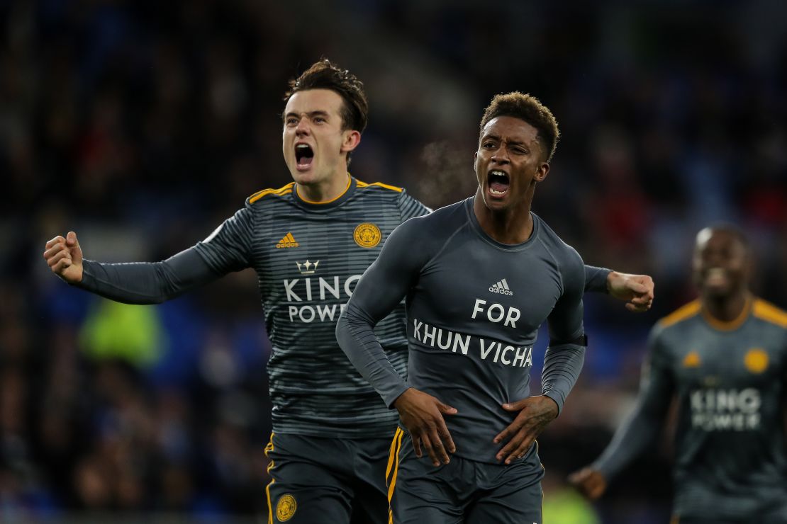 Demarai Gray celebrates with teammate Ben Chilwell, revealing a commemorative message for Vichai Srivaddhanaprabha during the Premier League match between Cardiff City and Leicester City.