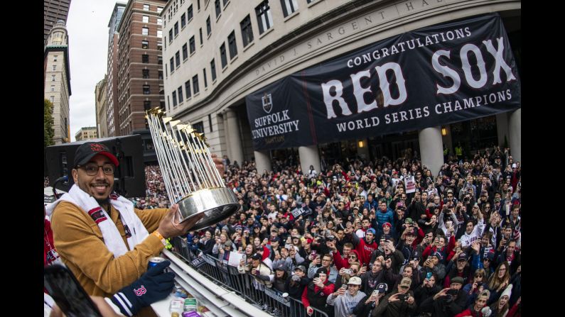 Mookie Betts of the Boston Red Sox displays the World Series trophy to fans during the rolling rally parade in Boston, Massachusetts. The Red Sox held the parade three days after defeating the Los Angeles Dodgers in the World Series.