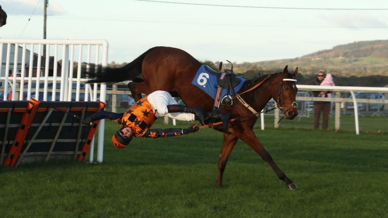 A jockey falls off of his horse during the BetBright Casino Juvenile Hurdle Race on October 28, 2018 in Wincanton, United Kingdom.