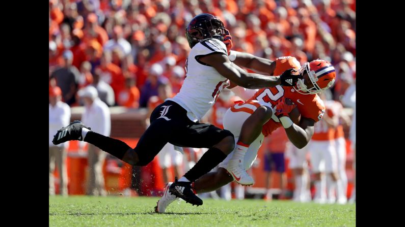 P.J. Blue of the Louisville Cardinals tackles Tavien Feaster of the Clemson Tigers during their game at Clemson Memorial Stadium on November 3, 2018 in Clemson, South Carolina.