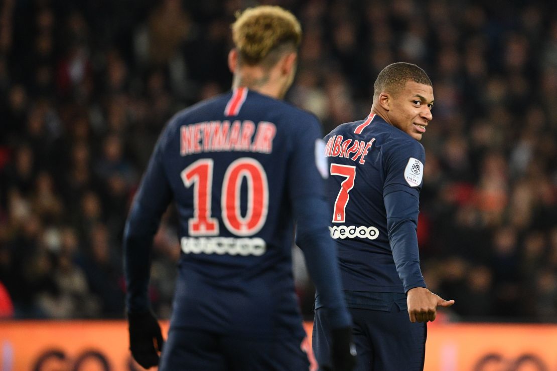 Mbappe gestures and smiles towards Neymar during a Ligue 1 match. 