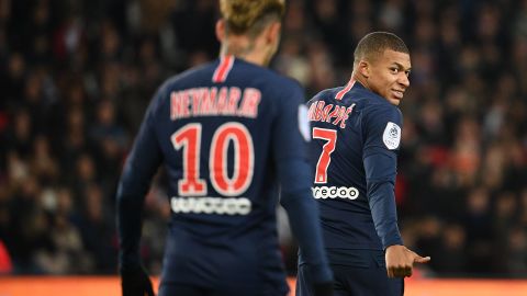 Mbappe gestures and smiles towards Neymar during a Ligue 1 match. 