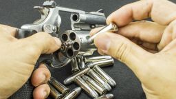 The .38mm and 9mm. bullet on hand reloading to a Revolver hand gun on black background. - weapon; Shutterstock ID 352751468; Job: -
