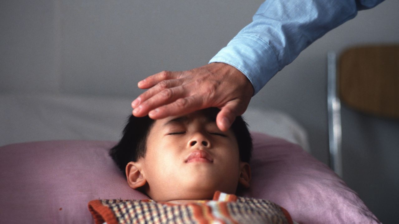 Qi gong master Liang Jian Sheng treats a short-sighted patient by transferring his energy to the young boy at a hospital in Guangzhou. 