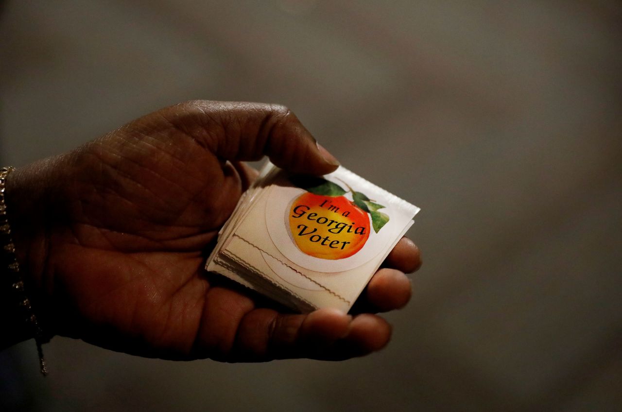 A poll worker hands out stickers in Atlanta.