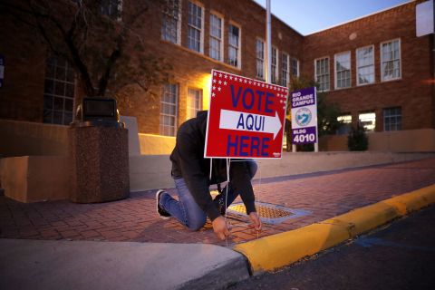 Volunteer Albert Lopez sets out signs directing voters to a polling place in El Paso, Texas.