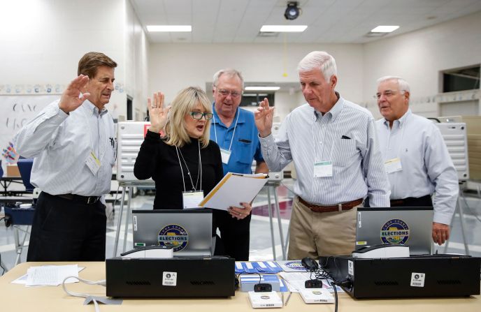 Election judges take an oath before opening a polling location in Arlington Heights, Illinois.