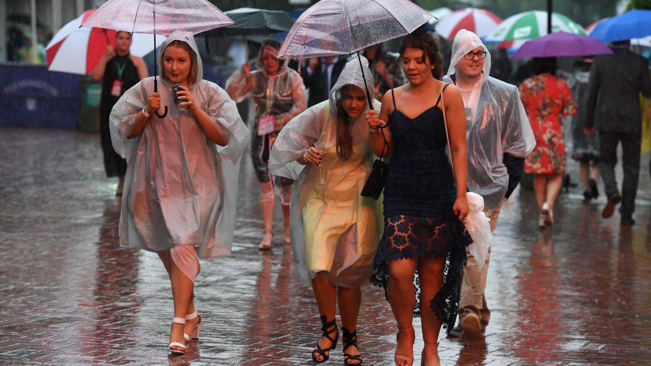 Race-goers take shelter from the rain ahead of the Melbourne Cup.