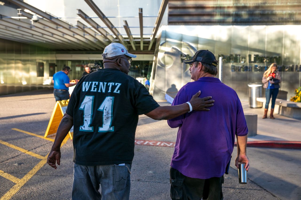 Wayne B. Cutts, left, a veteran who lives in a shelter for homeless veterans, walks with another veteran he drove to the the polls in Phoenix.