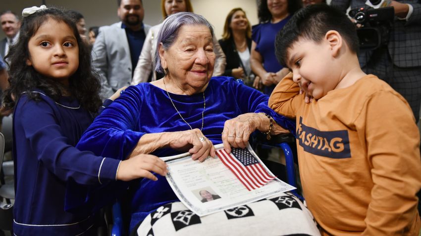 Maria Valles Bonilla, 106,  is seen with her great-grandchildren Asia Cortes (L) and Josh Cortes after becoming a US citizen during a naturalization ceremony at the US Citizenship and Immigration Services Washington District Office in Fairfax, Virginia on November 6, 2018. (Photo by MANDEL NGAN / AFP)        (Photo credit should read MANDEL NGAN/AFP/Getty Images)