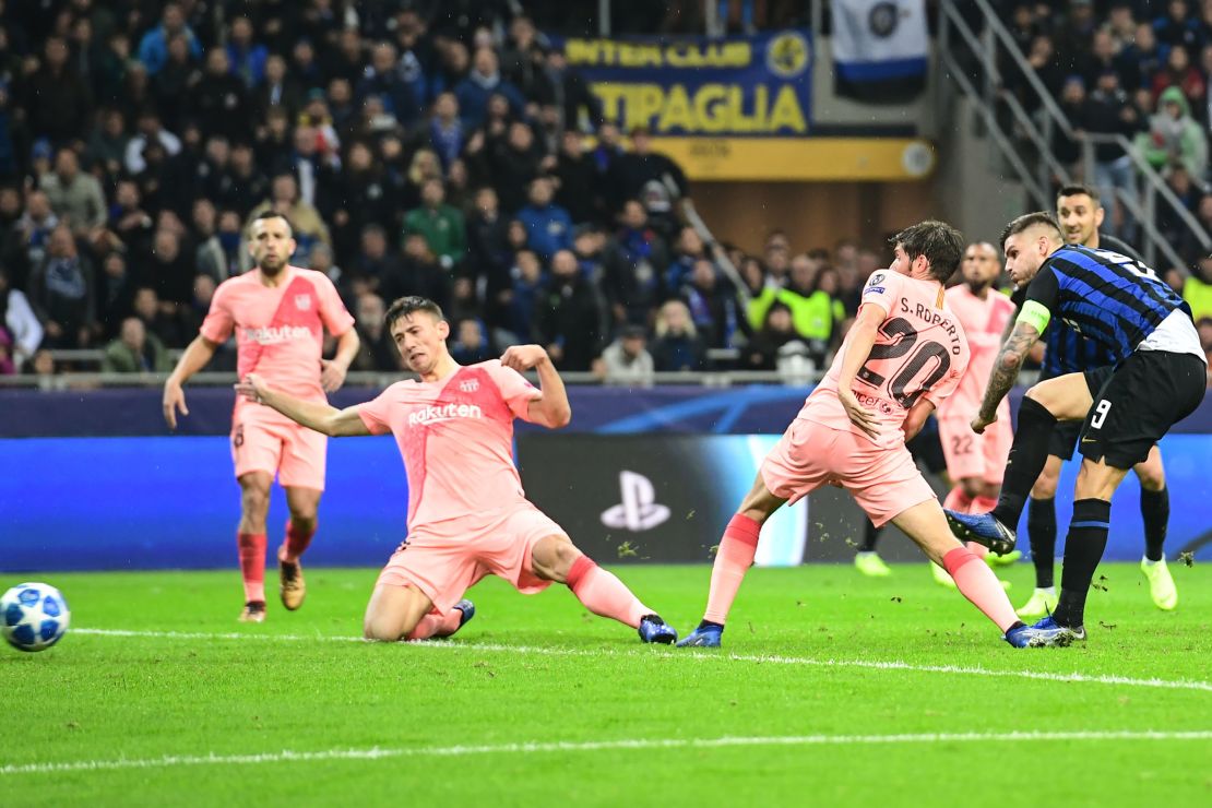 Mauro Icardi (R) of Inter Milan scores against Barcelona.