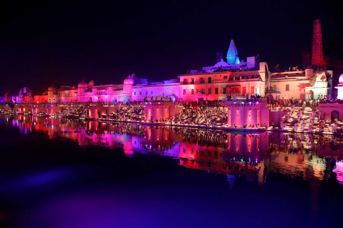 Participants light earthen oil lamps on the banks of the Sarayu river in an attempt to enter the Guinness World Records for the largest display of oil lamps on the eve of Diwali