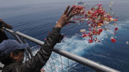 A relative sprinkles flowers for the victims of the crashed Lion Air flight 610 from an Indonesia Navy ship in the waters where the airplane is believed to have crashed in Tanjung Karawang, Indonesia, Tuesday, Nov. 6, 2018. (AP Photo/Tatan Syuflana)