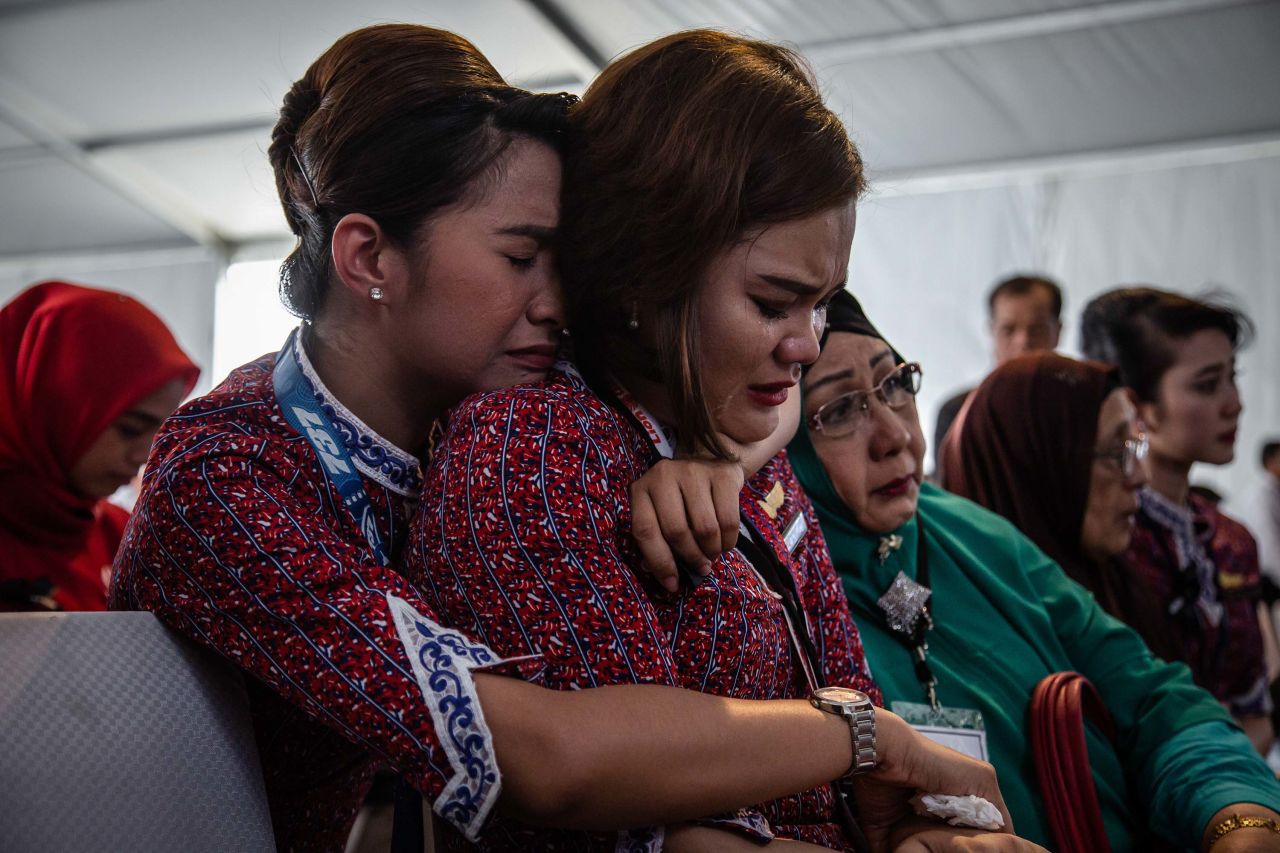Victims' families and colleagues react on a Navy ship as they're ferried to the crash site on November 6.