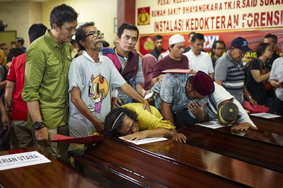 People in Jakarta grieve over the coffin of a relative on November 4.