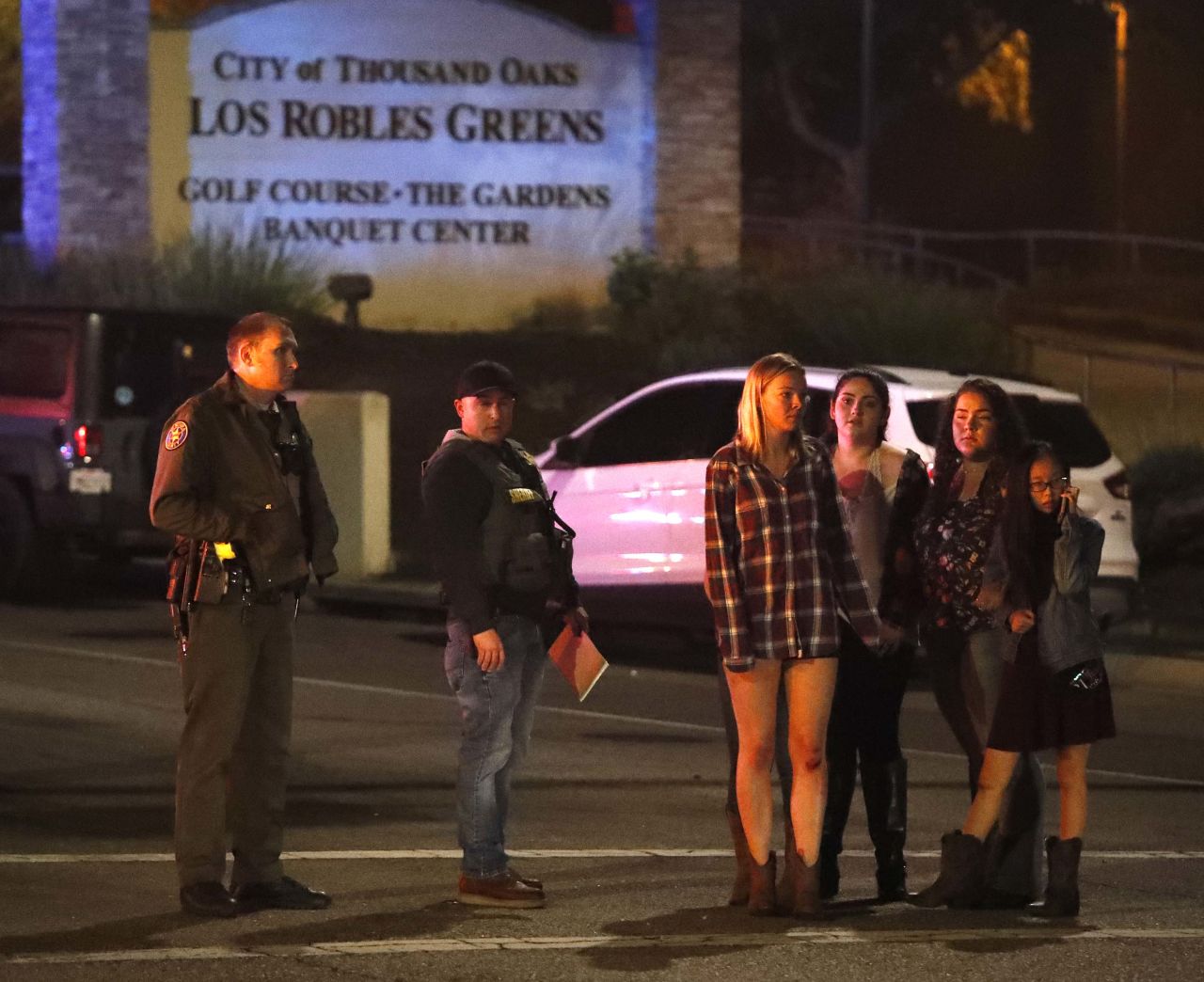 Women who fled from the shooting stand by a sheriff's deputy.