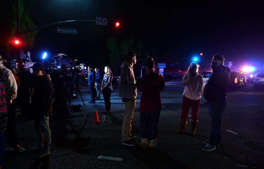 People watch as police vehicles close off the area outside a country music bar and dance hall in Thousand Oaks. 