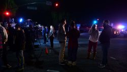 People stand and watch as the scene unfurls from the intersection of US 101 freeway and the Moorpark Rad exit as police vehicles close off the area outside a country music bar and dance hall in Thousand Oaks, west of Los Angeles, where a gunman opened fire late November 7, 2018, killing at least 12 people, US police said. (Photo by Frederic J. Brown/AFP)        (Photo credit should read FREDERIC J. BROWN/AFP/Getty Images)