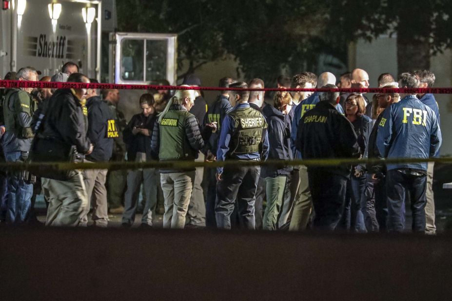 Investigators huddle at the command post near the bar.