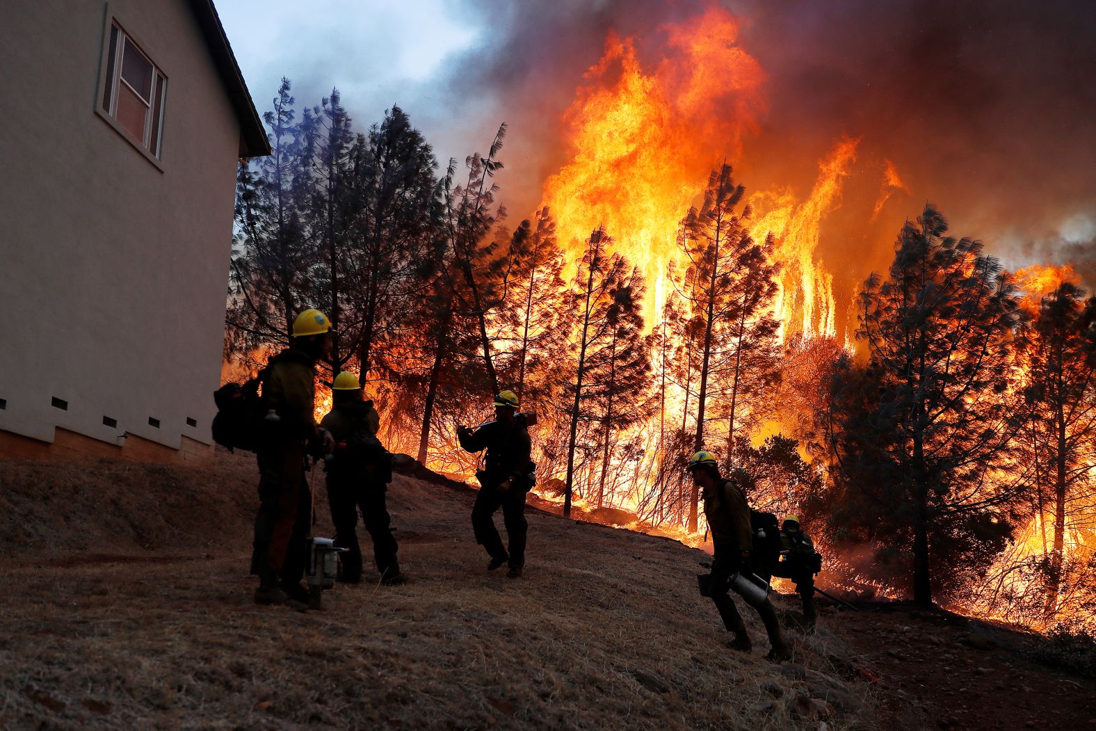 Firefighters monitor a back fire while attempting to save homes in Paradise on November 8.