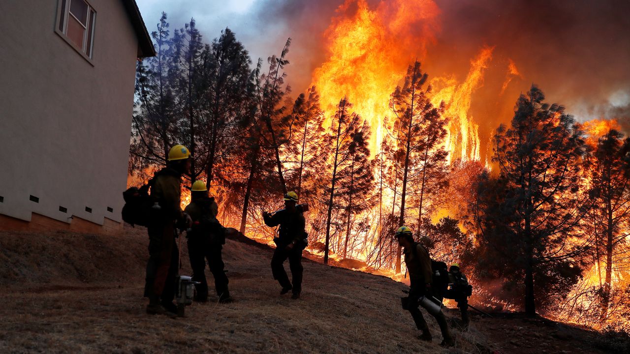 A group of US Forest Service firefighters monitor a back fire while battling to save homes from the Camp Fire in Paradise, California, on November 8.