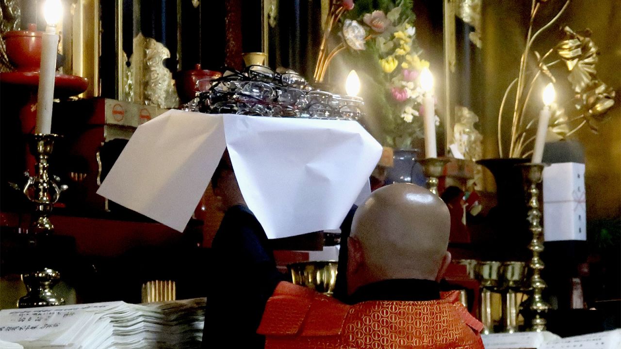 A Buddhist monk blesses pairs of glasses.