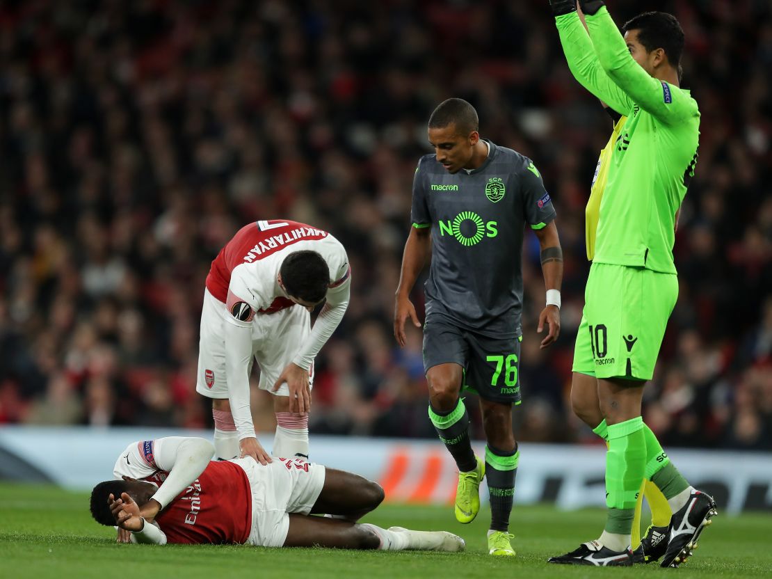 Arsenal's Henrikh Mkhitaryan stands over teammate Danny Welbeck after the England international was brought down.